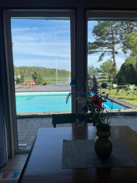 a view of a pool from a room with a vase of flowers at Paatsalu Sadam in Paatsalu