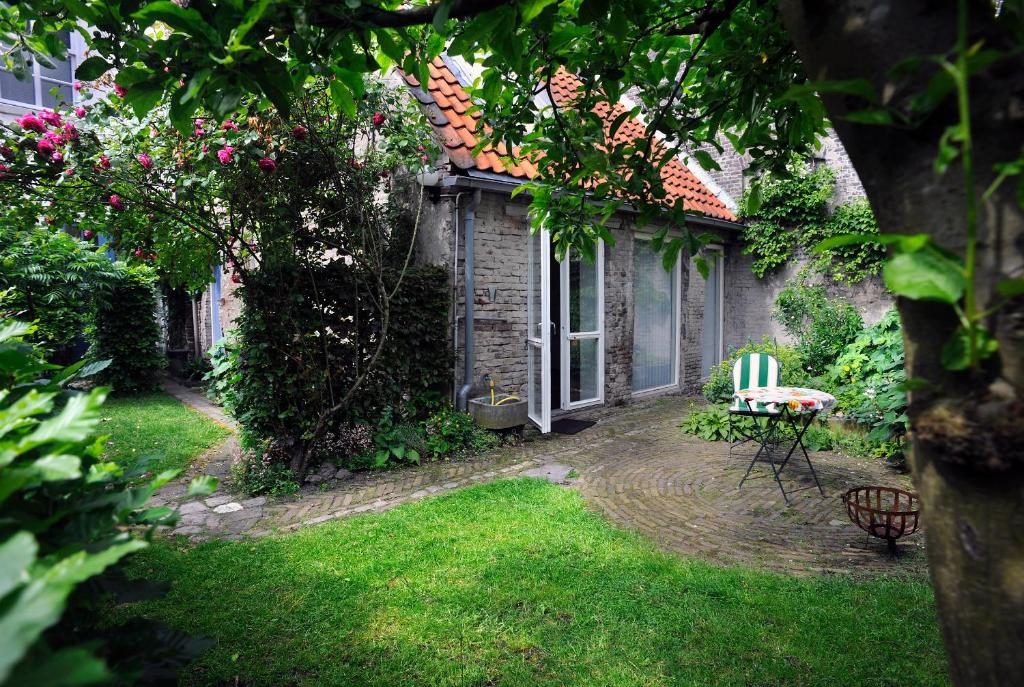 un jardín con una mesa y una silla en el patio en b&b Achter de Sterren, en Den Bosch