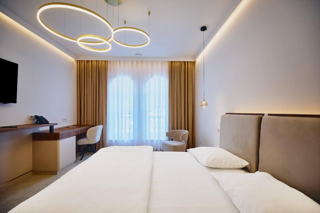 a hotel room with a bed and a desk at Casino & Hotel ADMIRAL Skofije in Zgornje Škofije
