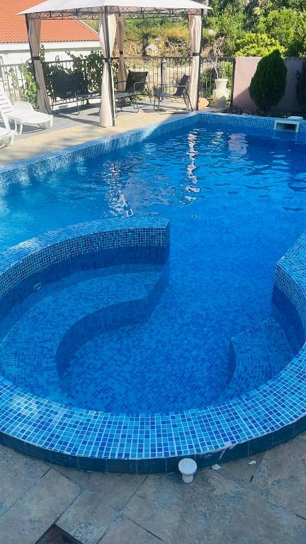 a large swimming pool with blue tiles in a yard at Apartments Lav Costas in Herceg-Novi