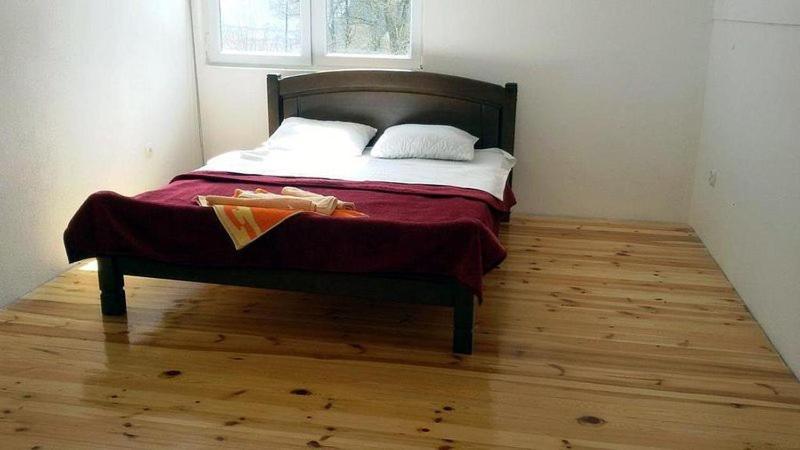 a bedroom with a bed with a wooden floor at Rafting Camp Apartments Tara in Žabljak