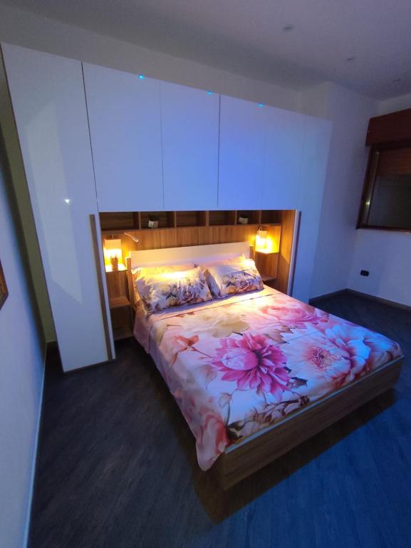 a bedroom with a large bed with a floral bedspread at Casa Borgo&Mare - Barletta in Barletta