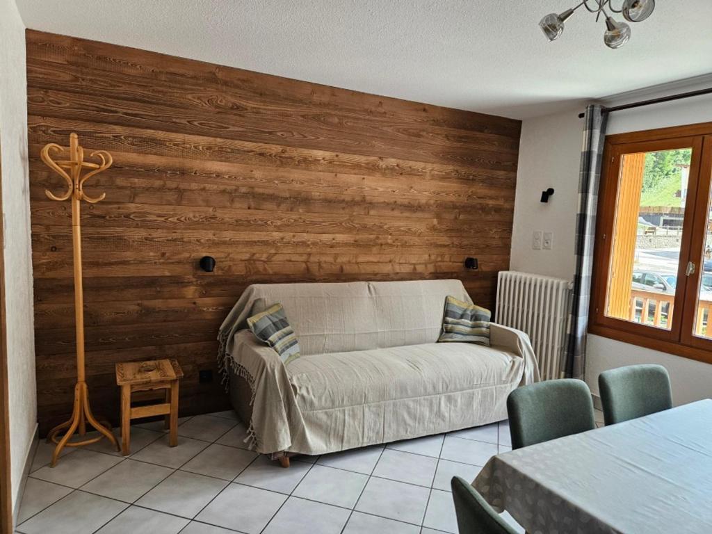- un salon avec un canapé et un mur en bois dans l'établissement Charmant 2 pièces, 5 pers, 3 étoiles, balcon sud, centre Valloire à 50m des pistes - FR-1-263-84, à Valloire