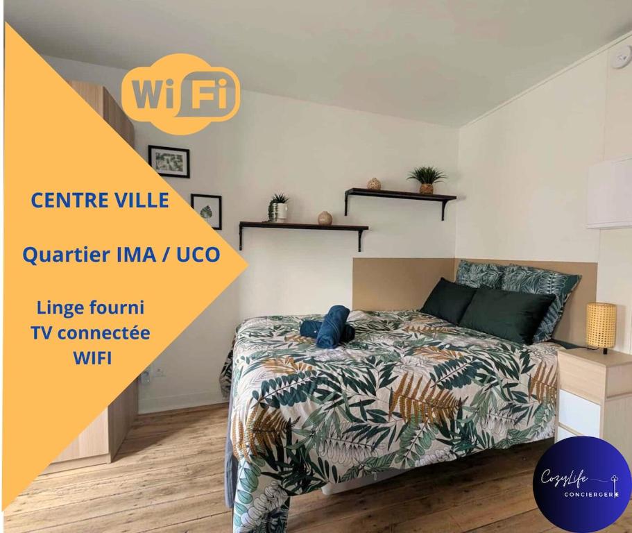 ein Schlafzimmer mit einem Bett mit einer Bettdecke darauf in der Unterkunft L'Oasis by Cozylife - Centre Ville in Niort