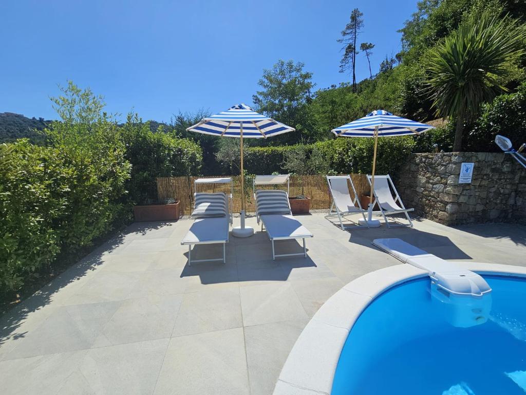 a patio with chairs and umbrellas and a pool at Orchidea in Beverino
