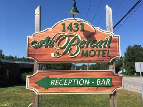 a sign for an aladdin beach motel with a green arrow at Motel Au Bercail in Temiscaming