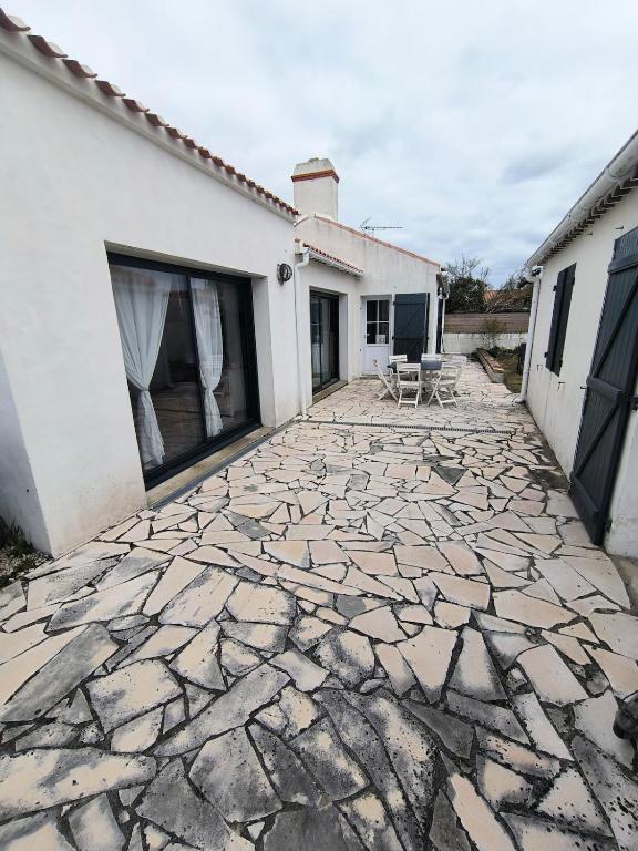 a stone patio in front of a house at Sur les dunes in La Guérinière