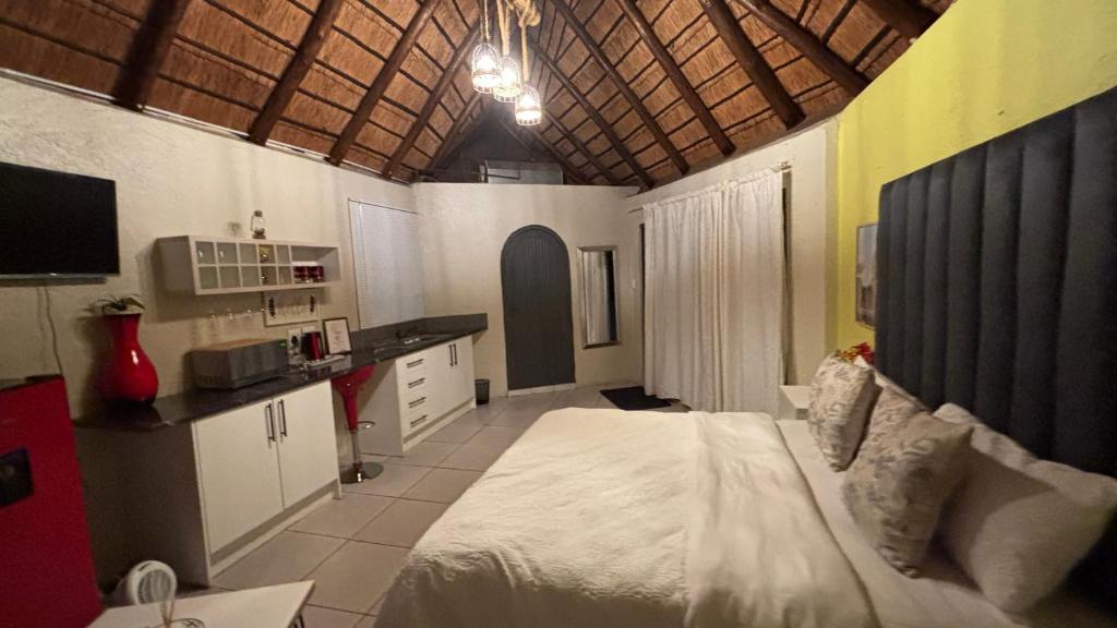 Un dormitorio con una cama grande y una cocina. en Harmony Spaces, en Kempton Park
