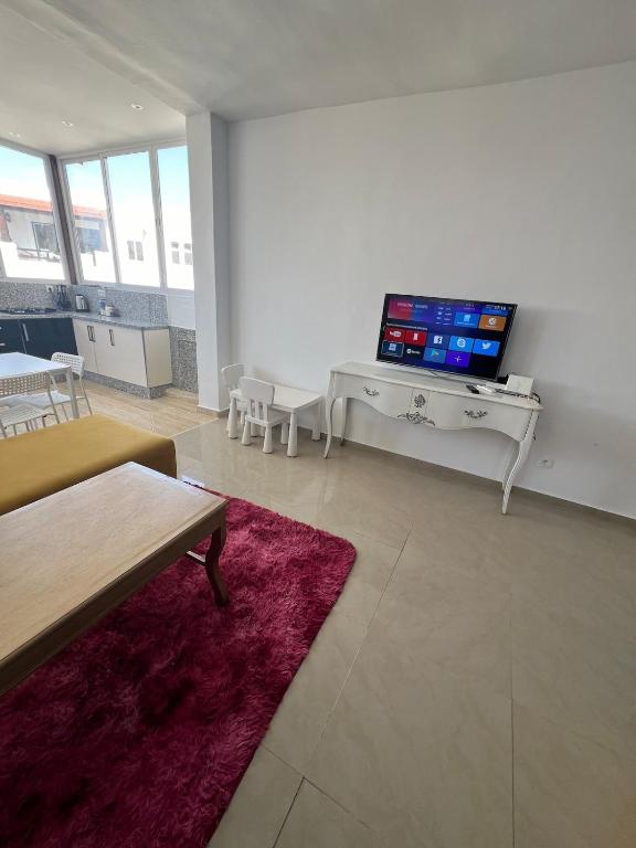 a living room with a tv on a white wall at Joli et confortable appartement in Cabo Negro