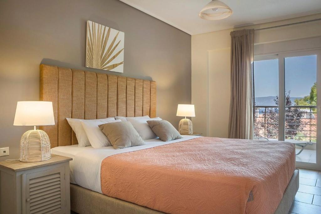 a bedroom with a large bed and a window at Deluxe Kefalonia Apartment Apartment Tangerine 1 Bedroom Pool Sea View Karavomilos in Karavomylos