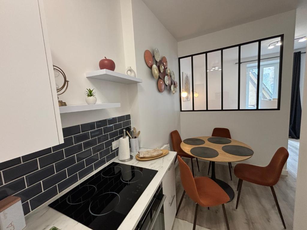 cocina con fogones y mesa con sillas en RARE Entre Luxe et Douceur Séjournez au Port de Saint-Goustan, en Auray