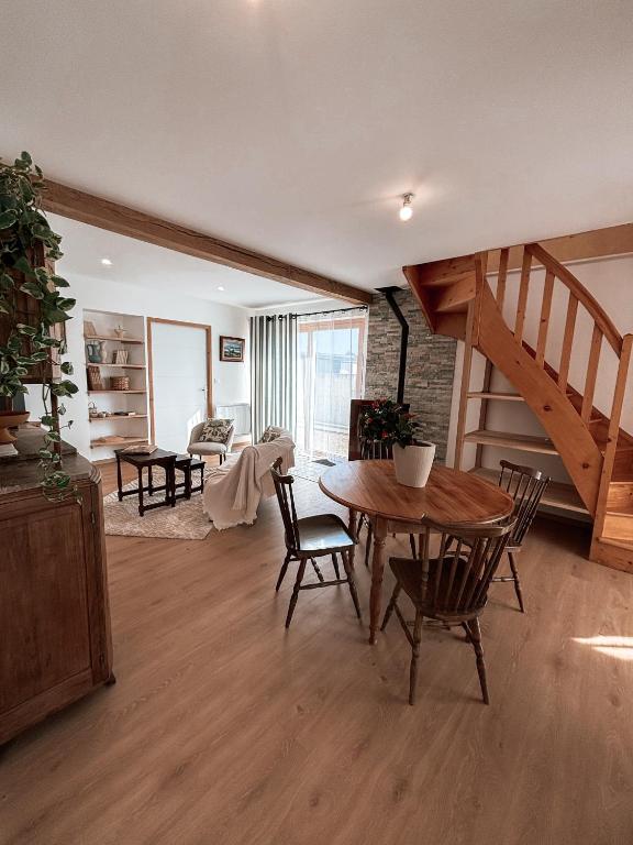 a living room with a table and chairs and a staircase at Maison Ty Pempoul rénovée, Confort, accessibilité et sérénité à Paimpol in Paimpol