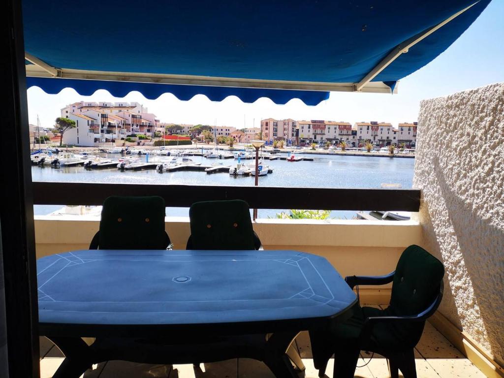 d'une table et de chaises sur un balcon avec vue sur le port. dans l'établissement Appartement T2 avec piscine, parking, animaux acceptés - Port Barcarès - FR-1-195-10, au Barcarès