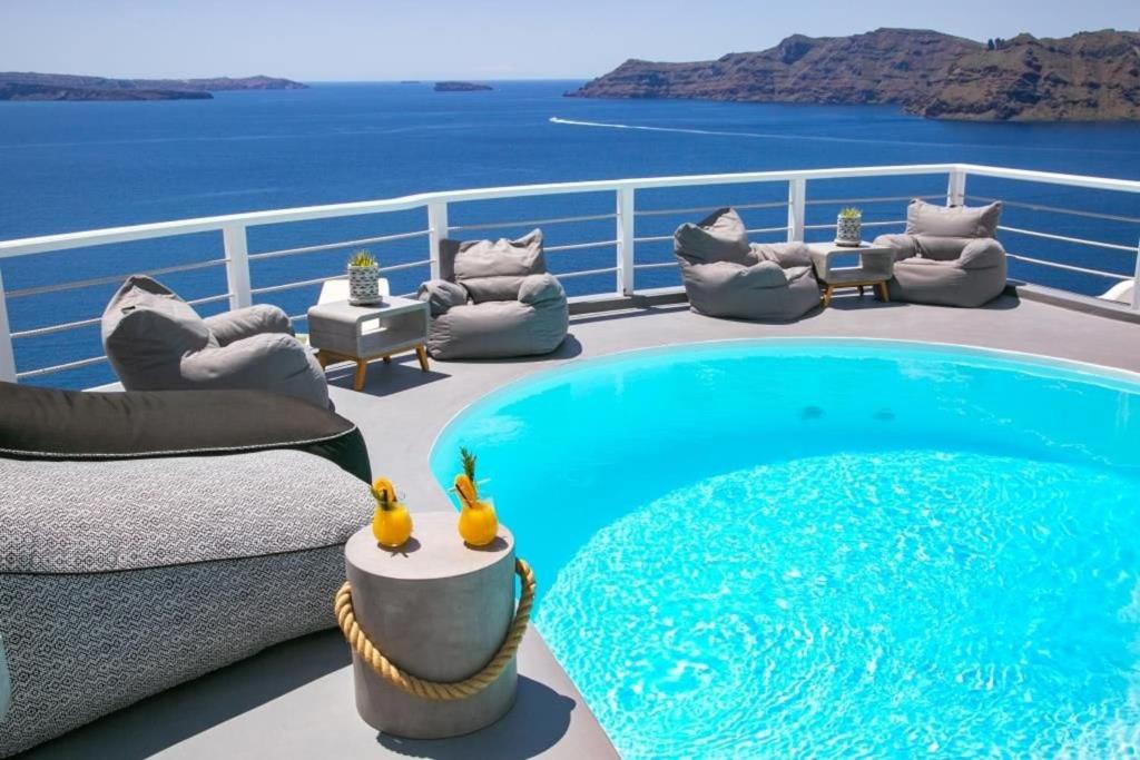 a balcony with a swimming pool on a cruise ship at Luxury Santorini Villa Ocean Breeze Villa 2 Bedrooms Sea & Caldera View Jacuzzi & Plunge Oia in Thólos