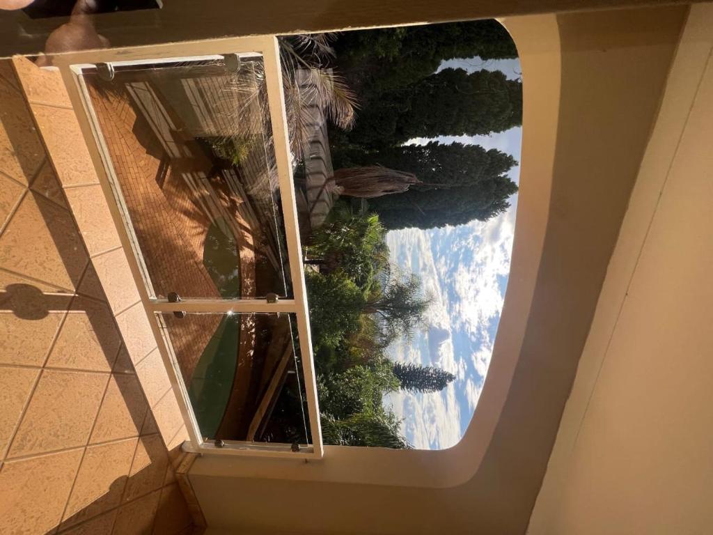 a window in a building with a view of trees at Bugera's Palace in Pretoria