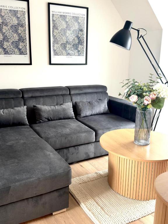 a living room with a black couch and a table at Almondvale Apartment in Livingston