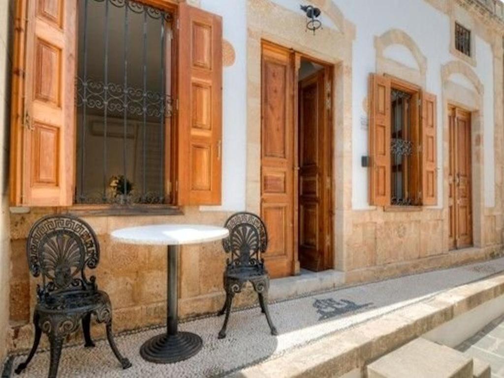 a table and two chairs in front of a building at Deluxe Rhodes Villa Villa Sokaki Well Furnished 2 Bedrooms Lindos in Líndos