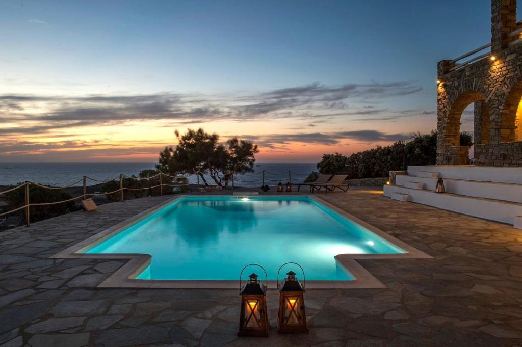 una piscina con due luci accanto all'oceano di Platinum Paros Villa Ocyrhoe Iii Villa 4 Bedrooms Private Pool & Fantastic Sea Views Parikia a Paroikia
