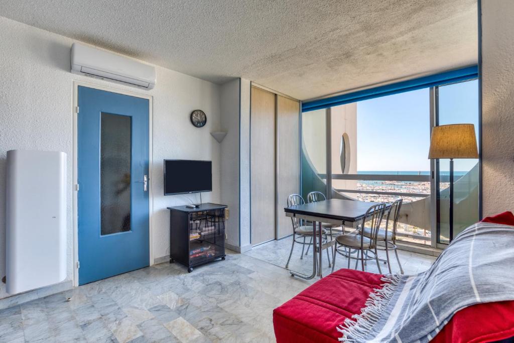 - une chambre avec un lit et une table avec vue dans l'établissement Sur les hauteurs du Fidji, à La Grande Motte