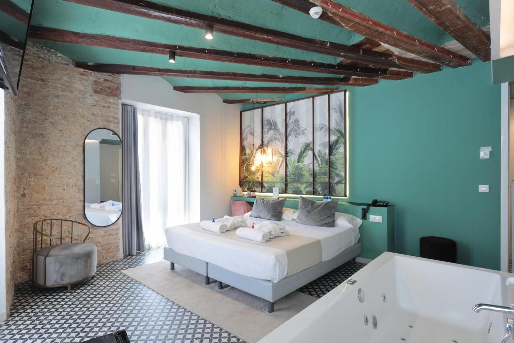 a bedroom with a bed and a bath tub at YOU & CO. Quart Boutique in Valencia