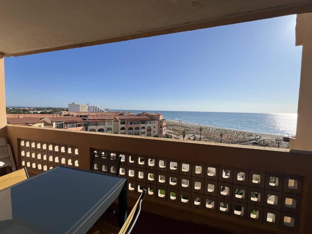 un balcon avec une table et une vue sur l'océan dans l'établissement Appartement T2 Climatisé avec Piscine, Terrasse et Accès Direct Plage, 4 Couchages – Le Barcarès - FR-1-81-510, au Barcarès