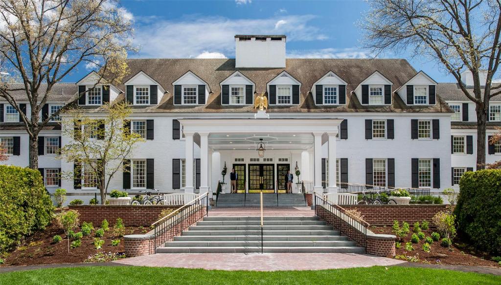 a large white building with stairs leading to the front door at Woodstock Inn & Resort in Woodstock