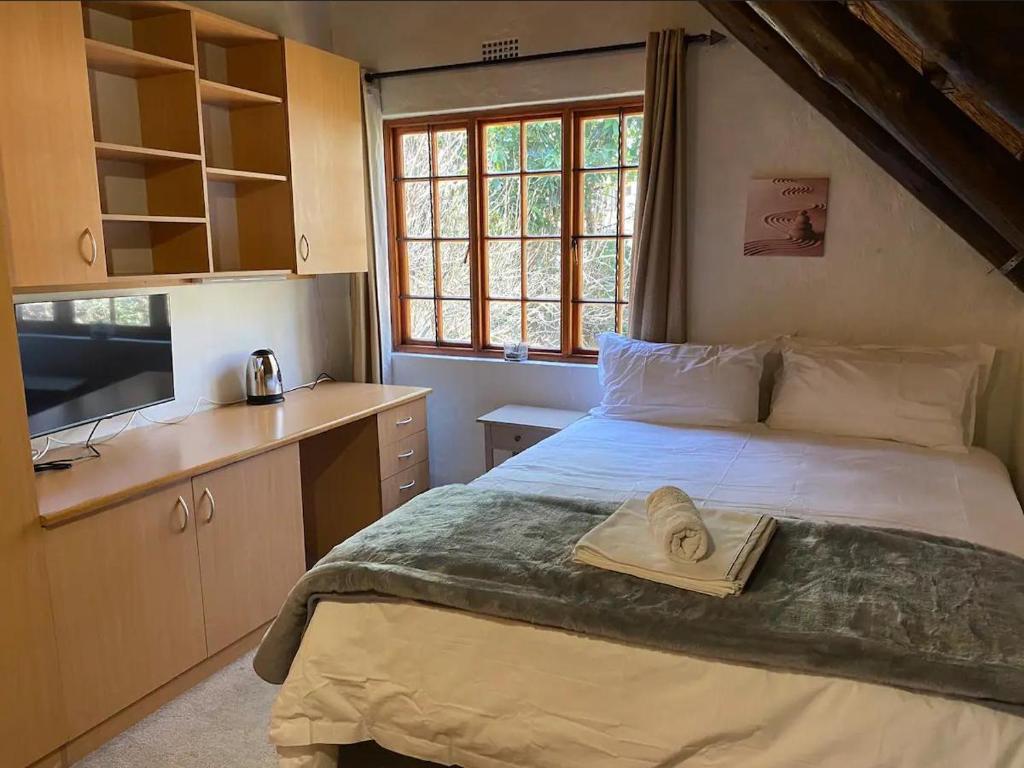 sypialnia z łóżkiem i kapeluszem na nim w obiekcie Tuscan Rose w mieście Johannesburg