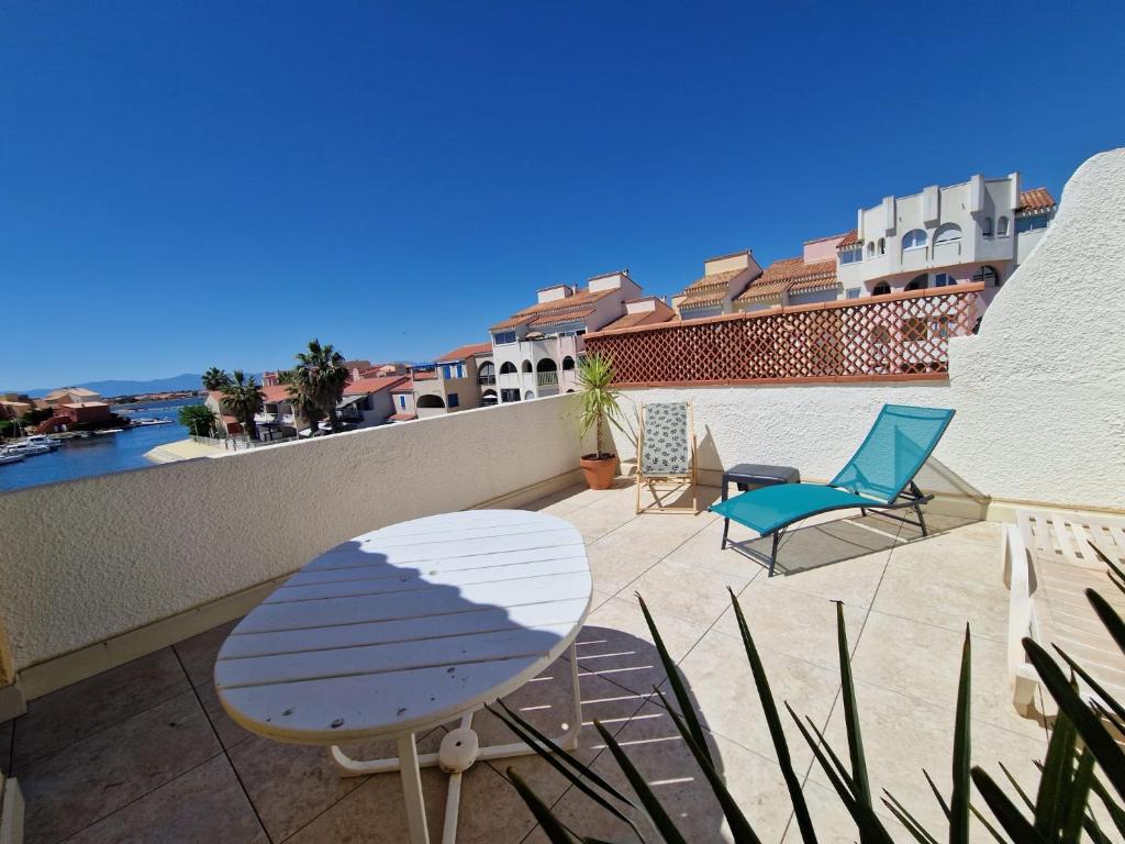 un patio avec des chaises et une table sur un balcon dans l'établissement Bel appartement double terrasse, au Barcarès