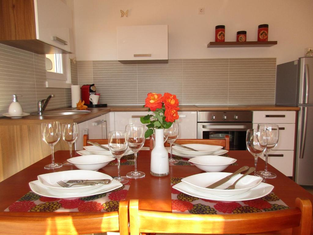 eine Küche mit einem Tisch mit Tellern und Weingläsern in der Unterkunft Iva Doren in Vir