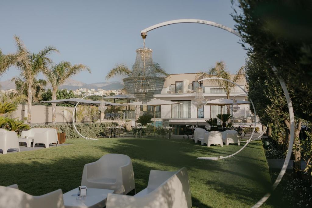 カンポフェリーチェ・ディ・ロッチェッラにあるPalmar Boutique Hotelの白いテーブルと椅子のあるホテルの眺め