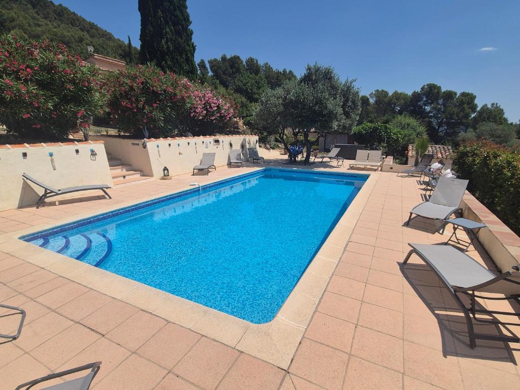 une piscine avec des chaises longues et une piscine dans l'établissement Gites Colline De Sollies, à Salernes