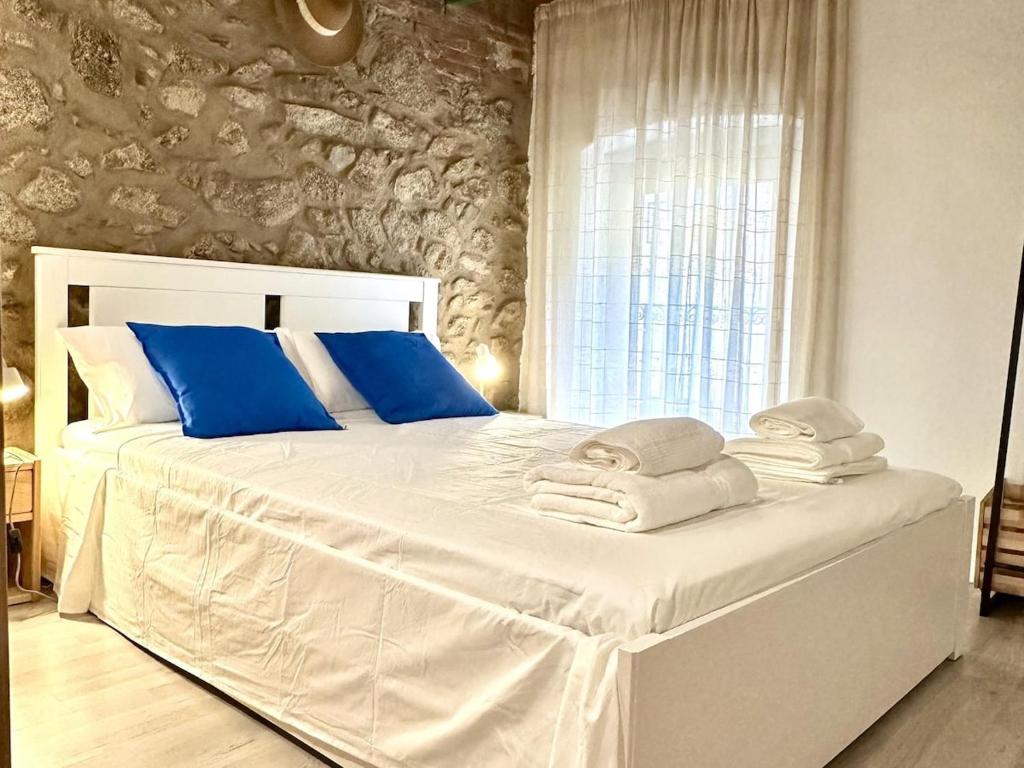 a bedroom with a large white bed with blue pillows at La Caseta de Palamós in Palamós