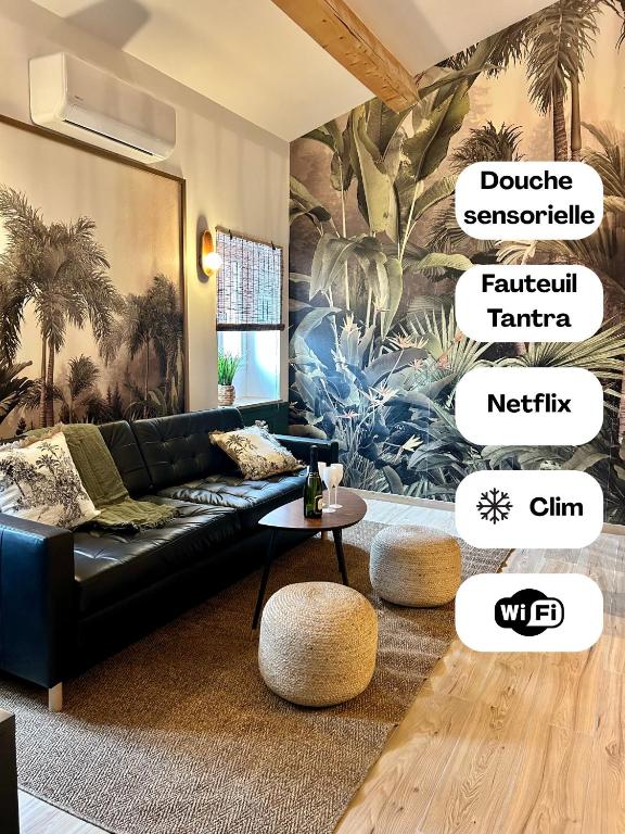 a living room with a black couch and a table at L Indiana douche sensorielle in Le Muy