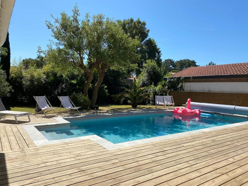 a swimming pool with a red float in a backyard at Villa Labenne Ocean - piscine, 500 mètres de la plage in Labenne