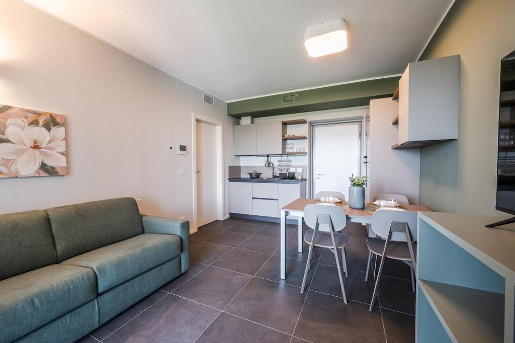 a living room with a couch and a table and a kitchen at Park Towers 15 - Design - Large Terrace - AC in Milan