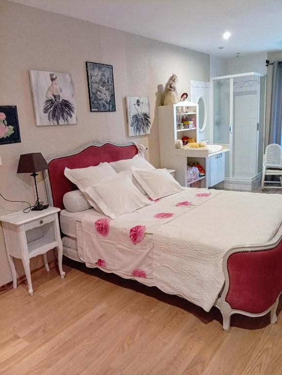 a bedroom with a large bed with pink flowers on it at Chambre Romance in Pajay