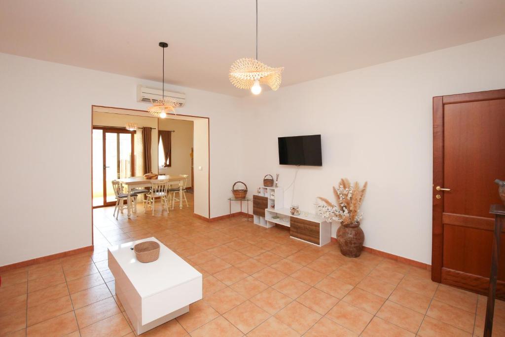 a living room with a white couch and a tv at Roma 19 in Castelsardo