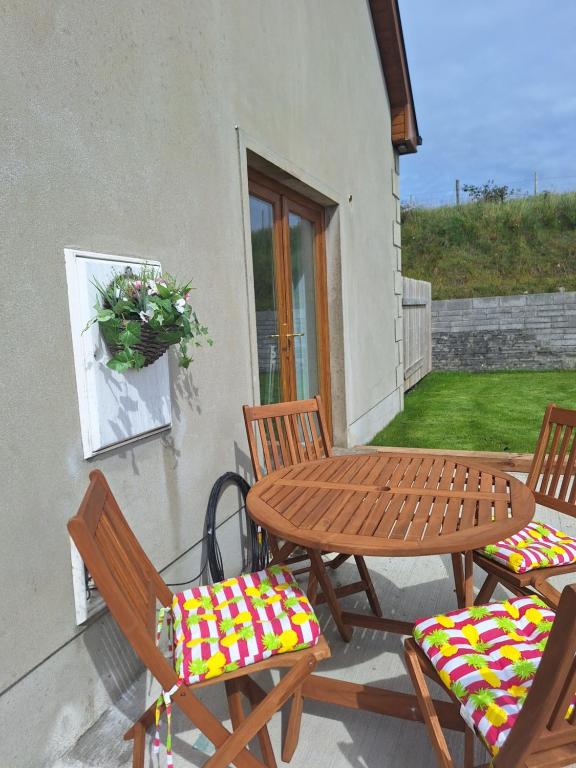 a wooden table and chairs on a patio at SANDYS SHORE APARTMENT in Donegal