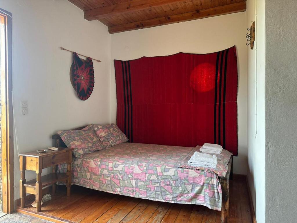 a small bed in a room with a red curtain at Koumos in Kalyves
