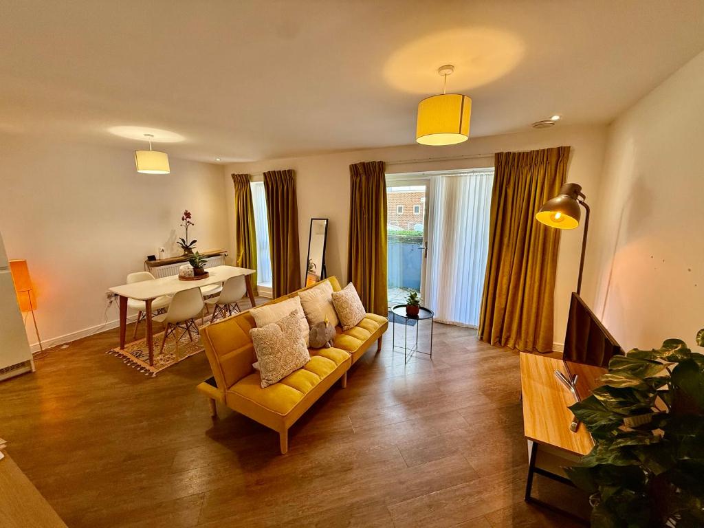 a living room with a yellow couch and a table at Issara Apartments 35 - Great Location & Private Parking in Portsmouth