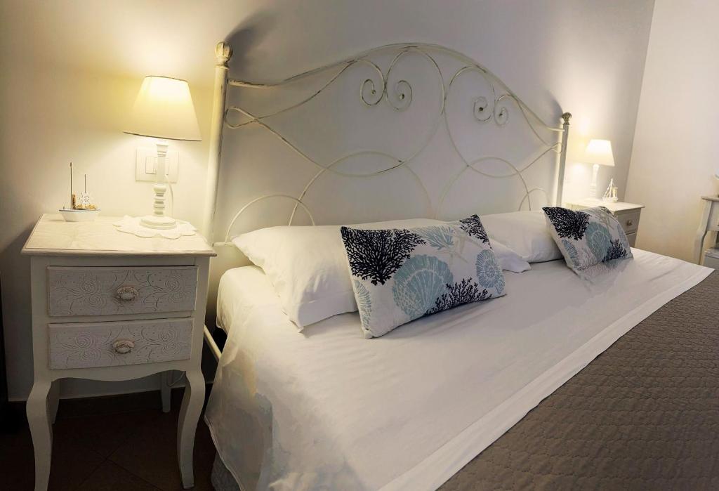 a bedroom with a white bed and a night stand at Alba b&b in Polignano a Mare