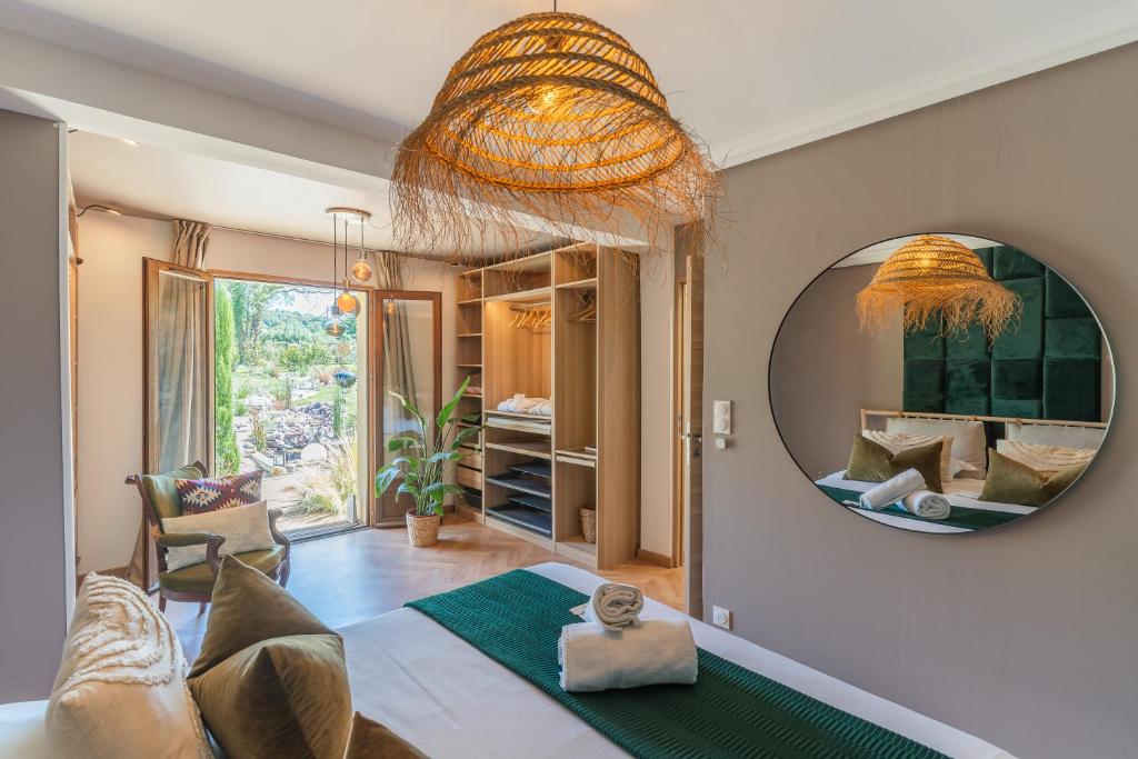 a living room with a mirror and a couch at Maison du Bonheur avec Rivière & Spa, 4 chambres & 2 SDB in Tourville-en-Auge