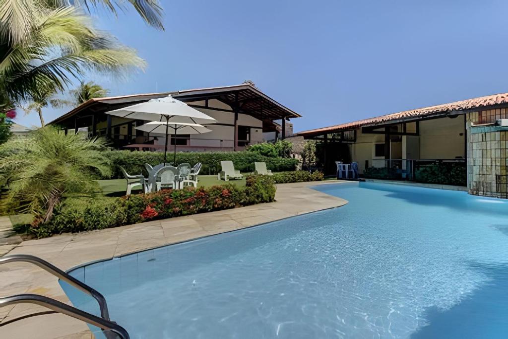 a swimming pool in front of a house at Linda no BEACH PARK-16 pessoas - HOUSINGCEARÁ in Berra Bode
