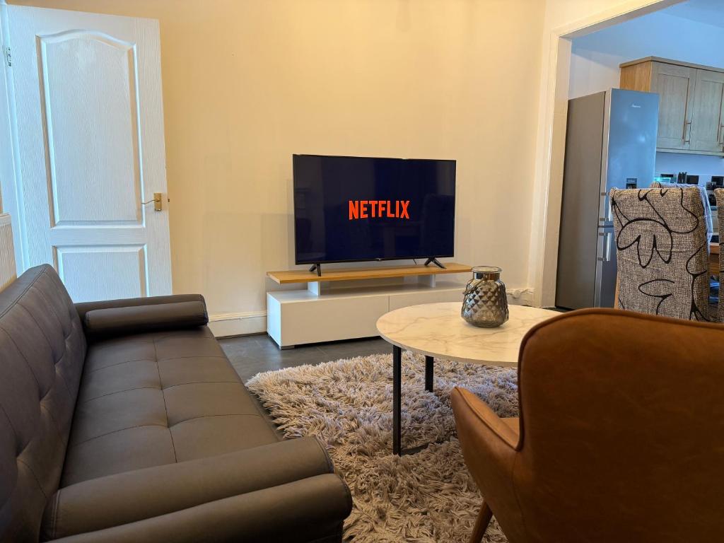 a living room with a couch and a tv at 3 Bedroom House - Doncaster Serviced Accommodation - House-Close To Centre -A1 & M18 - Contractors - Business Travellers - Families in Doncaster