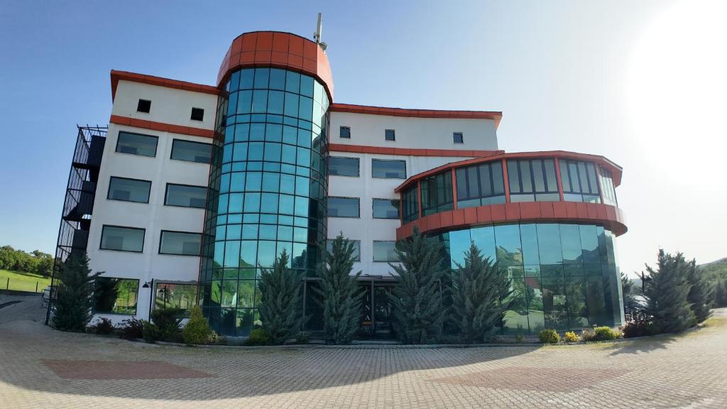 a large glass building with trees in front of it at Lina Garden Otel in Bingol