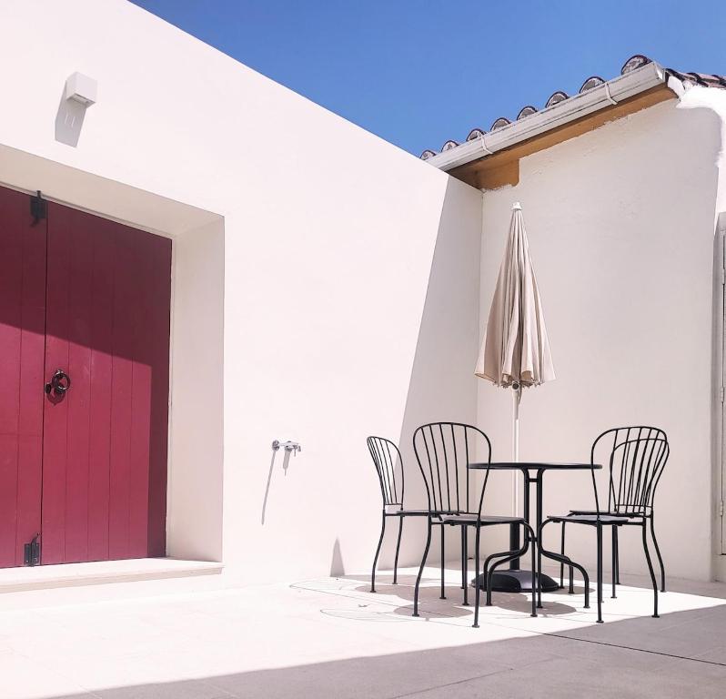 a patio with a table and chairs and a red door at Castelo House in Castelo de Vide