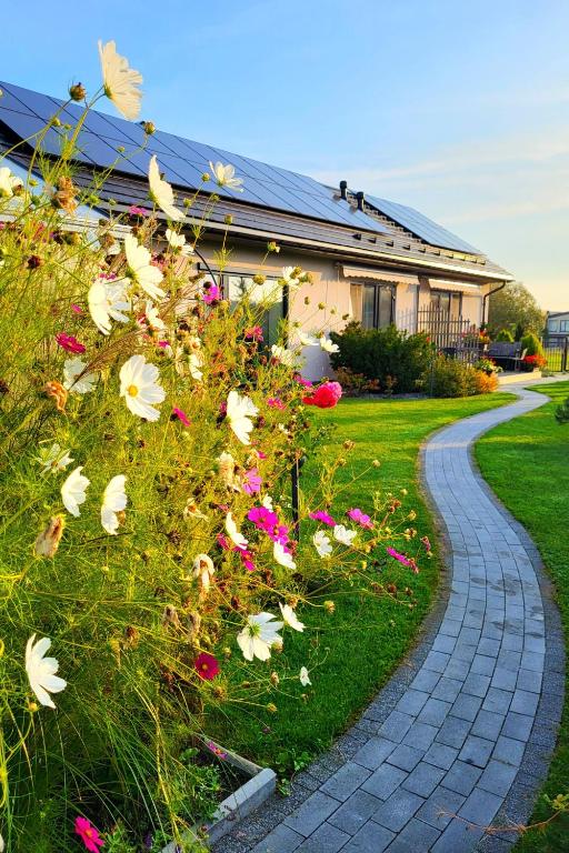 ein Pfad, der zu einem Haus mit Blumen führt in der Unterkunft Nemirsetos kopos in Palanga