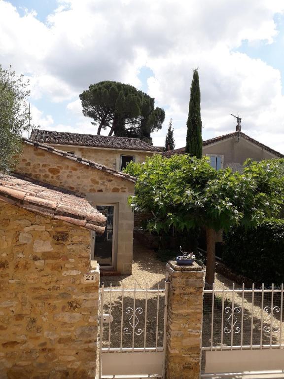 une maison en pierre avec un portail et une clôture dans l'établissement Charming small house close to Uzès, à Foissac
