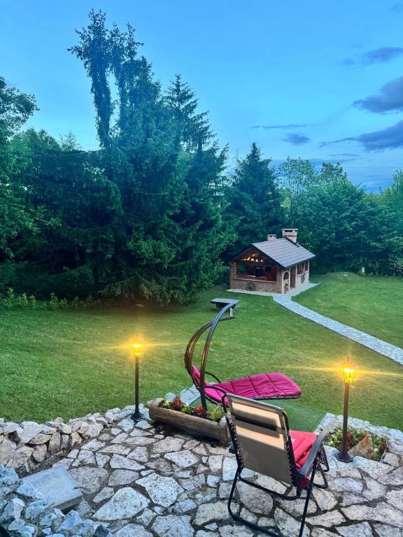 a yard with two chairs and a table and a house at Forest Escape Banja Luka in Banja Luka