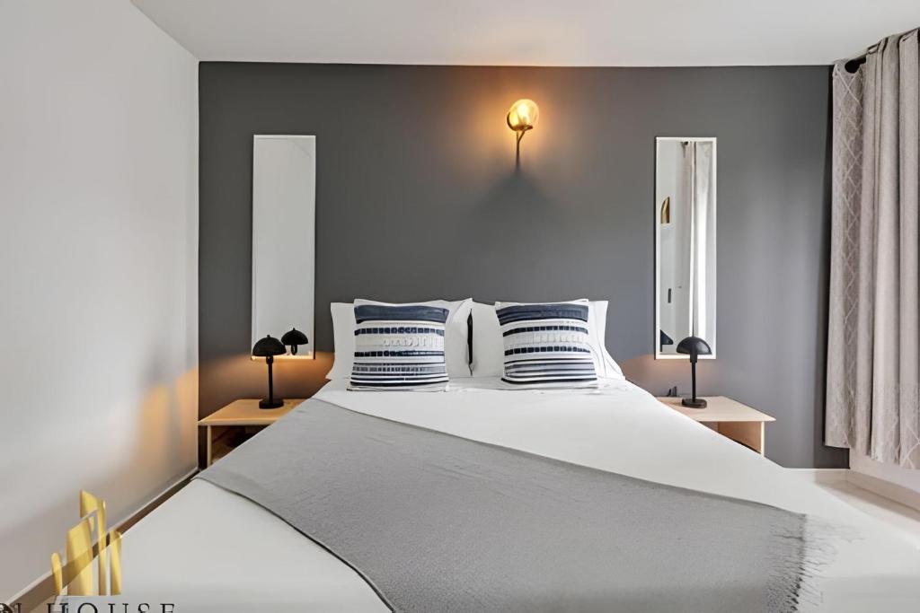 a bedroom with a large white bed with blue pillows at Aria Living 300 - Style and Urban Comfort in Guayaquil